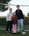 Simon med syskonen Simon och Lilja framför ett fotbollsmål.