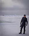 Alex Lüdge står isbjörnsvakt under en tur med forskarna till isstationen.