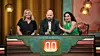 Tre deltagare sitter bakom ett belyst quizbord i en tv-studio och tittar mot kameran.