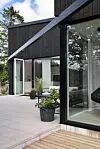 Nybyggt hus med stora glaspartier och altan i söderläge