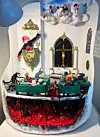 Detaljerad miniatyr av kyrkinteriör med bänkar, präst och röd underjordisk scen.