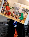 Miniatyrkonstverk med figur som faller från ett ljust rum ner i ett mörkt hål.