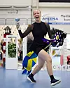 Tävlande springer med käpphäst och pokal på inomhustävling.