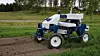 Elektrisk Ekobot-robot kör mellan grödrader på en åker och rensar ogräs.