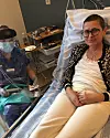 Patient i sjukhussäng får vård av personal i skyddsutrustning