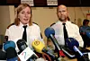 Två poliser i uniform talar i ett podium fyllt av mikrofoner från flera medier.