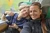 Två personer ler mot kameran och tar en selfie i ett tåg med utsikt över gröna fält.