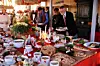 Personer tar mat från ett fullastat svenskt smörgåsbord med sill, lax och bröd.