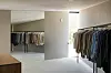 enorm walk-in-closet med rader av kläder speglar och stort fönster
