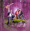 Tre personer sitter och står på en gammal bil i en skog, med rosa rök runtom och en gitarr upplyft i luften.