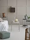 Stilren inredning med soffbord, puff, sidobord och väggskåp i mörka och ljusa toner.