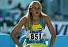 Friidrottare i blågul dräkt med nummerlapp 851 sitter framåtlutad på en stol.