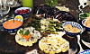 Grillade grönsaker med paprikaaioli, pinjenötter och granatäppelkärnor på ett bord.
