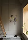 Minimalistisk hall med trästege, väggdekorationer, skor på matta och stort fönster.