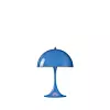Blå bordslampa med kupolformad skärm på vit bakgrund.