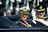 Svergies kung Carl XVI Gustaf och Norges kung Harald V i en öppen svart bil vinkar mot åskådare under en ceremoniell färd.