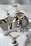Fem cocktailglas med ljus dryck står på en spegelbricka.