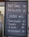 Svart griffeltavla med handskriven lunchmeny och priser.