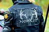 Baksidan av en svart motorcykelväst med Norrut-logga och en gul axelpatch syns.