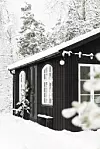 svart attefallshus i snö