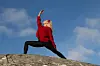 Johanna Hector utövar yoga på en klippa.