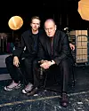 Valter Skarsgård och Peter Haber sitter på stolar i en mörk lokal med starkt ljus och utrustning i bakgrunden.
