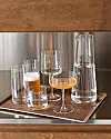 Glas och en karaff placerade på en bricka på en bänkskiva.