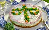 Tårta med matjessill dekorerad med midsommarstång av dill och rom.