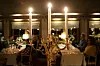 Kandelaber med tända ljus framför middagsgäster i en mysig restaurang.
